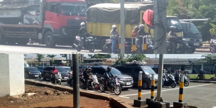 Suasana arus lalu lintas di perempatan Cileungsi yang dipadati kendaraan roda dua truk dan mobil pribadi