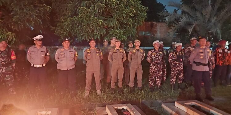 Suasana khidmat saat upacara Renungan Suci di Taman Makam Pahlawan Cileungsi pada malam menjelang Hari Ulang Tahun Kemerdekaan RI Tampak barisan pejabat TNI Polri dan sipil berdiri dengan sikap sempurna di antara nisan nisan yang diterangi cahaya lilin