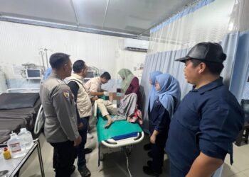 Petugas Polsek Tambang bersama tenaga medis menangani pelaku pencurian motor yang mengalami luka akibat diamuk massa, di ruang perawatan RS Bhayangkara.