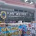 Ribuan Warga Pati Bersiap Demo Besar Tuntut Bupati Sudewo Mundur - Utusan Rakyat 001 - Utusan Rakyat Gambar Foto memperlihatkan tumpukan kardus air mineral dan logistik donasi warga yang memenuhi muka Kantor Bupati Pati dengan spanduk tuntutan pelengseran Bupati Sudewo menggambarkan kesiapan dan kebulatan tekad massa aksi