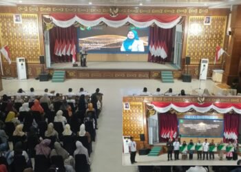 Kepala BPJS Ketenagakerjaan Cabang Dumai, Dina Khairina, memberikan sambutan dalam acara penyerahan simbolis kartu peserta program perlindungan bagi pekerja rentan di Kota Dumai, Rabu (3/9/2025). (Inset) Wakil Wali Kota Dumai, Sugiyarto, bersama perwakilan BPJS Ketenagakerjaan saat menyerahkan kartu peserta secara simbolis kepada perwakilan pekerja.