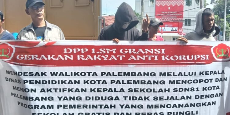 Sejumlah massa dari LSM Gerakan Rakyat Anti Korupsi GRANSI membentangkan spanduk tuntutan saat menggelar aksi damai Aksi tersebut mendesak Wali Kota Palembang untuk mencopot Kepala Sekolah SDN 81 Palembang yang diduga tidak sejalan dengan program sekolah gratis dan bebas pungli